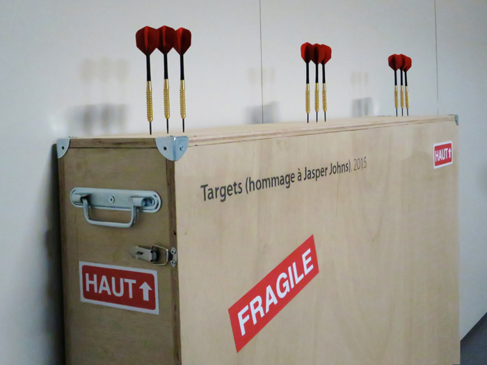 lien vers l'installation "Targets (hommage à Jasper Johns)" vue de la caisse de transport et des fléchettes